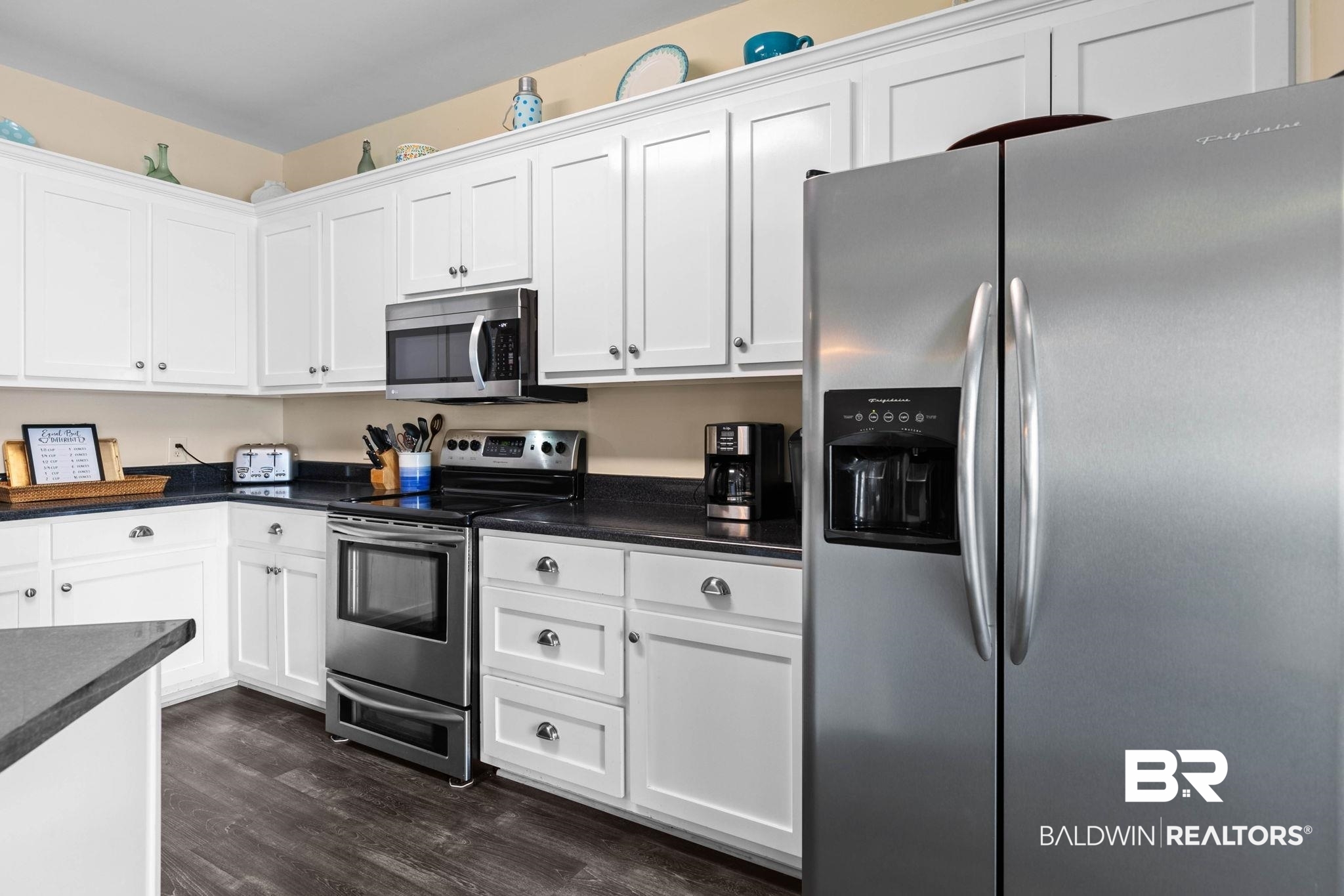 6802 Shore Drive Elberta, AL 36530 - Photo 13 of 34 Kitchen featuring white cabinetry, dark countertops, stainless steel appliances, and wood-finish flooring