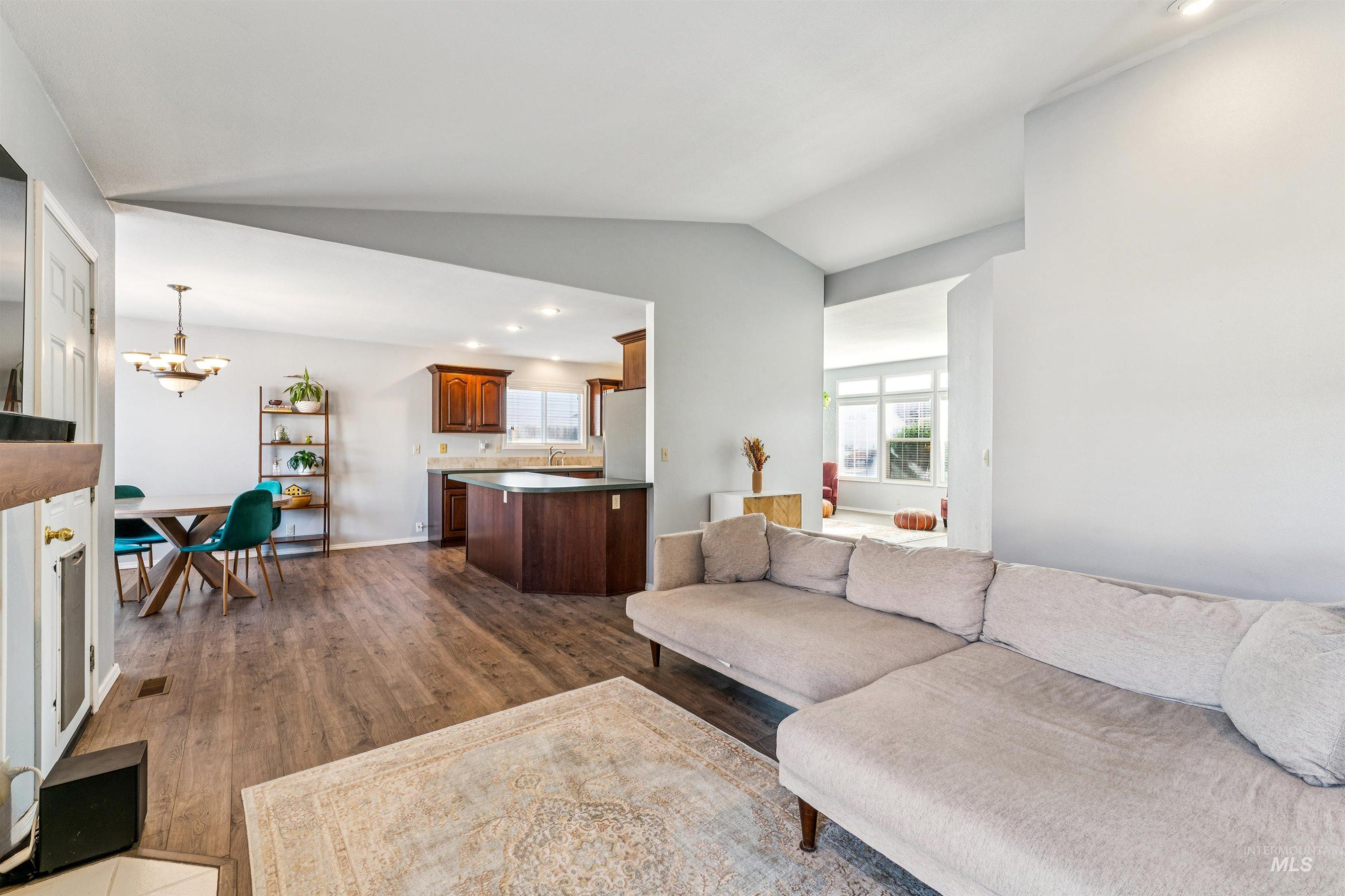 11968 West Bronte Street Boise, ID 83709 - Photo 14 of 48 Living room featuring recessed lighting, lofted ceiling, dark wood-style flooring, and a chandelier