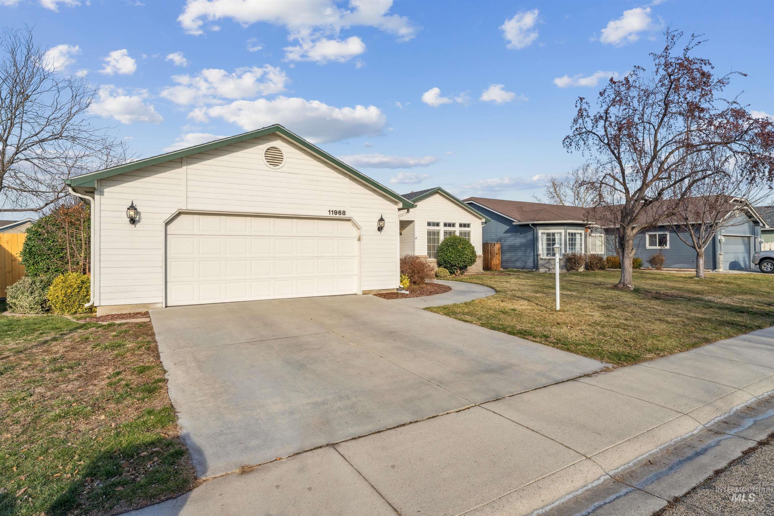 11968 West Bronte Street Boise, ID 83709 - Photo 2 of 48 Ranch-style house with concrete driveway, a garage, and a front lawn