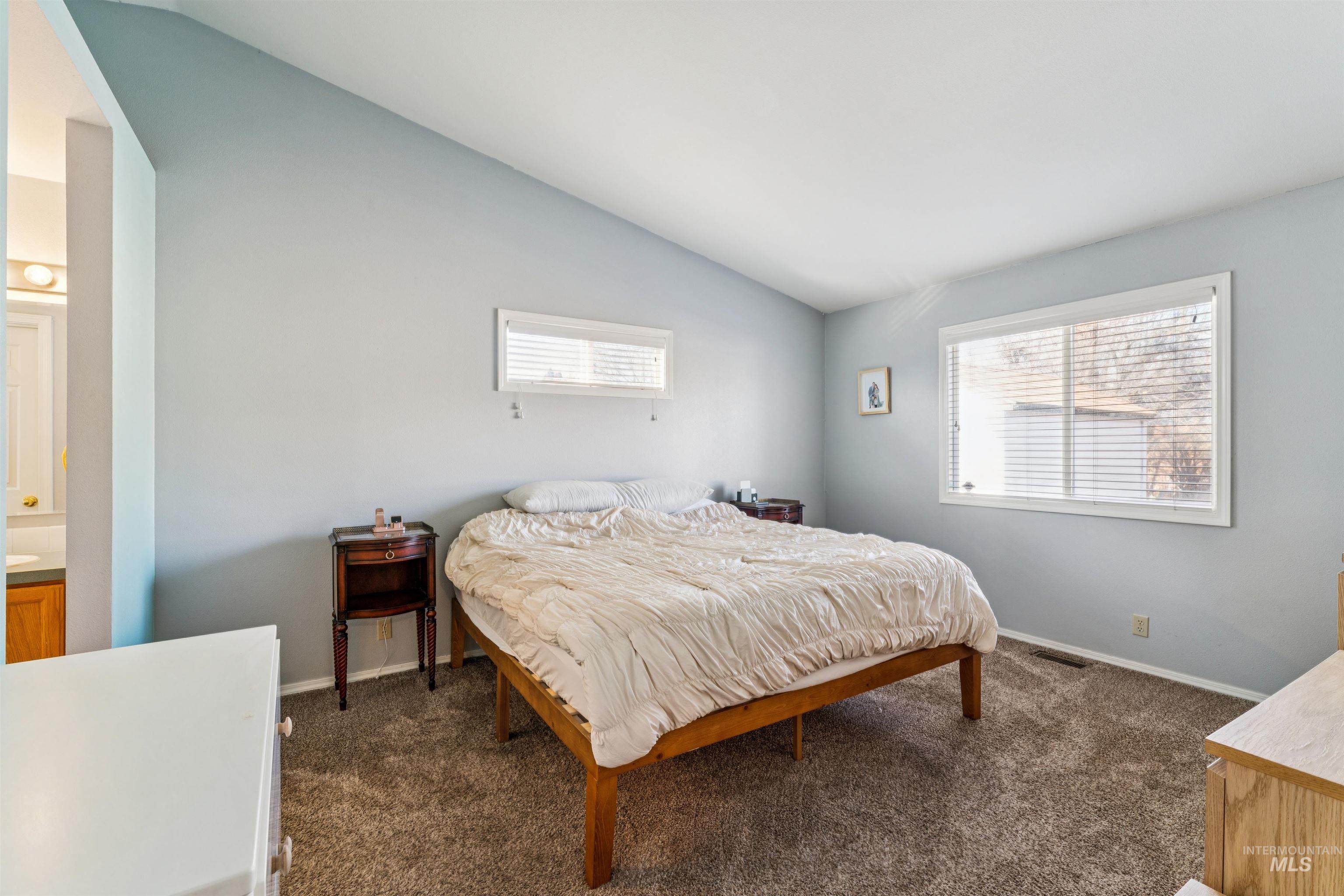 11968 West Bronte Street Boise, ID 83709 - Photo 21 of 48 Bedroom featuring lofted ceiling, dark carpet, and multiple windows