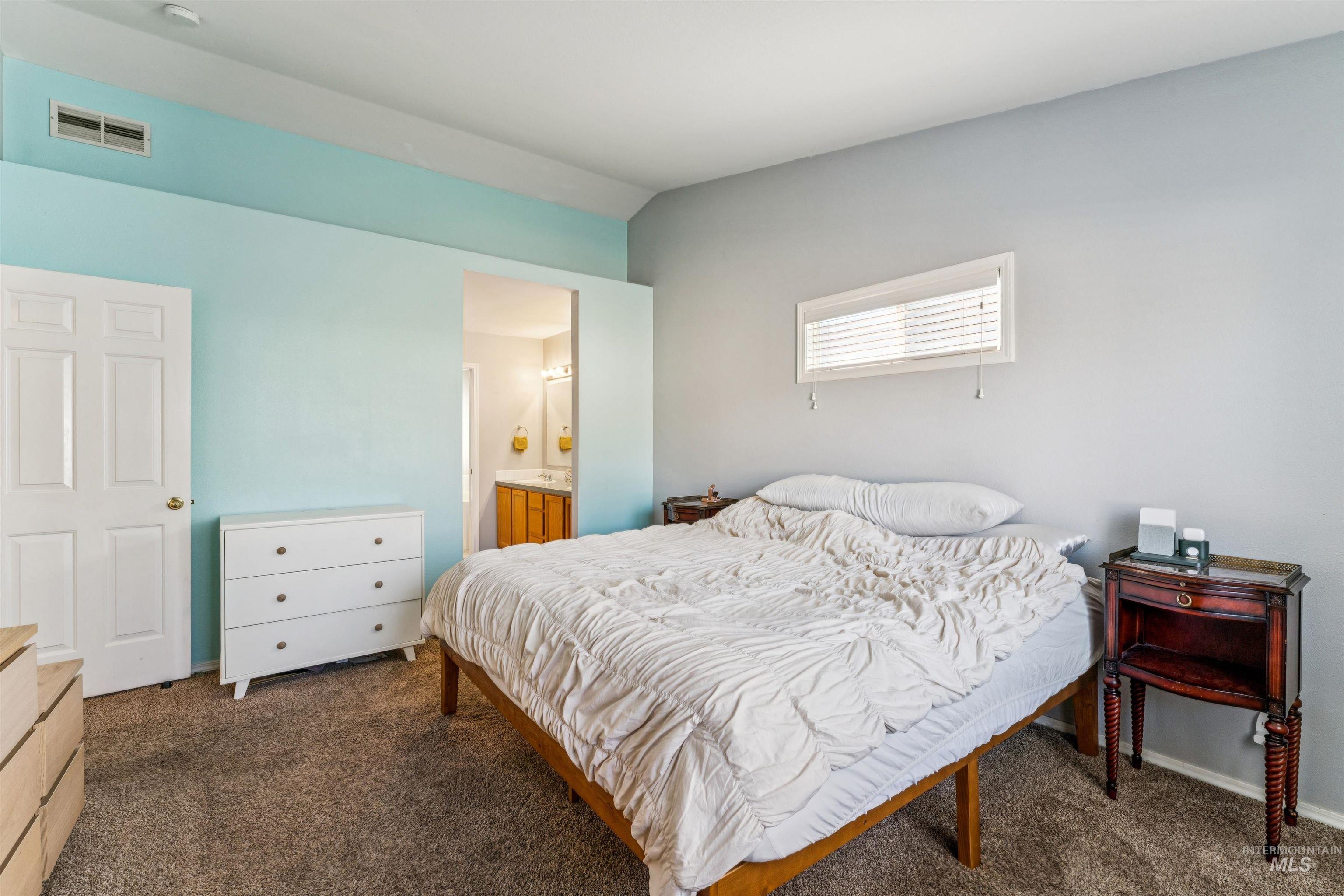 11968 West Bronte Street Boise, ID 83709 - Photo 22 of 48 Bedroom with dark colored carpet, ensuite bathroom, and lofted ceiling