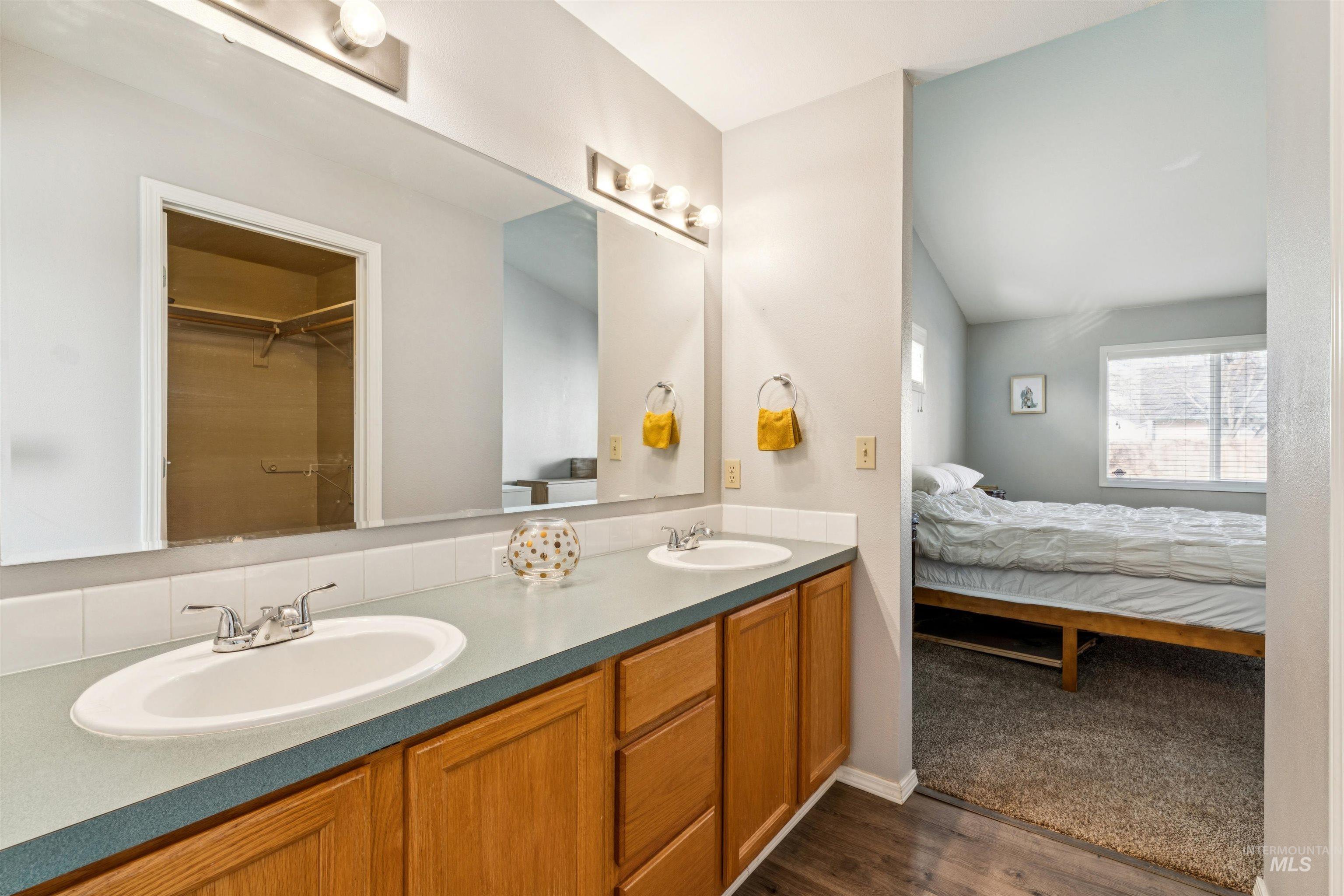 11968 West Bronte Street Boise, ID 83709 - Photo 28 of 48 Bathroom featuring double vanity, a spacious closet, and dark wood-style flooring