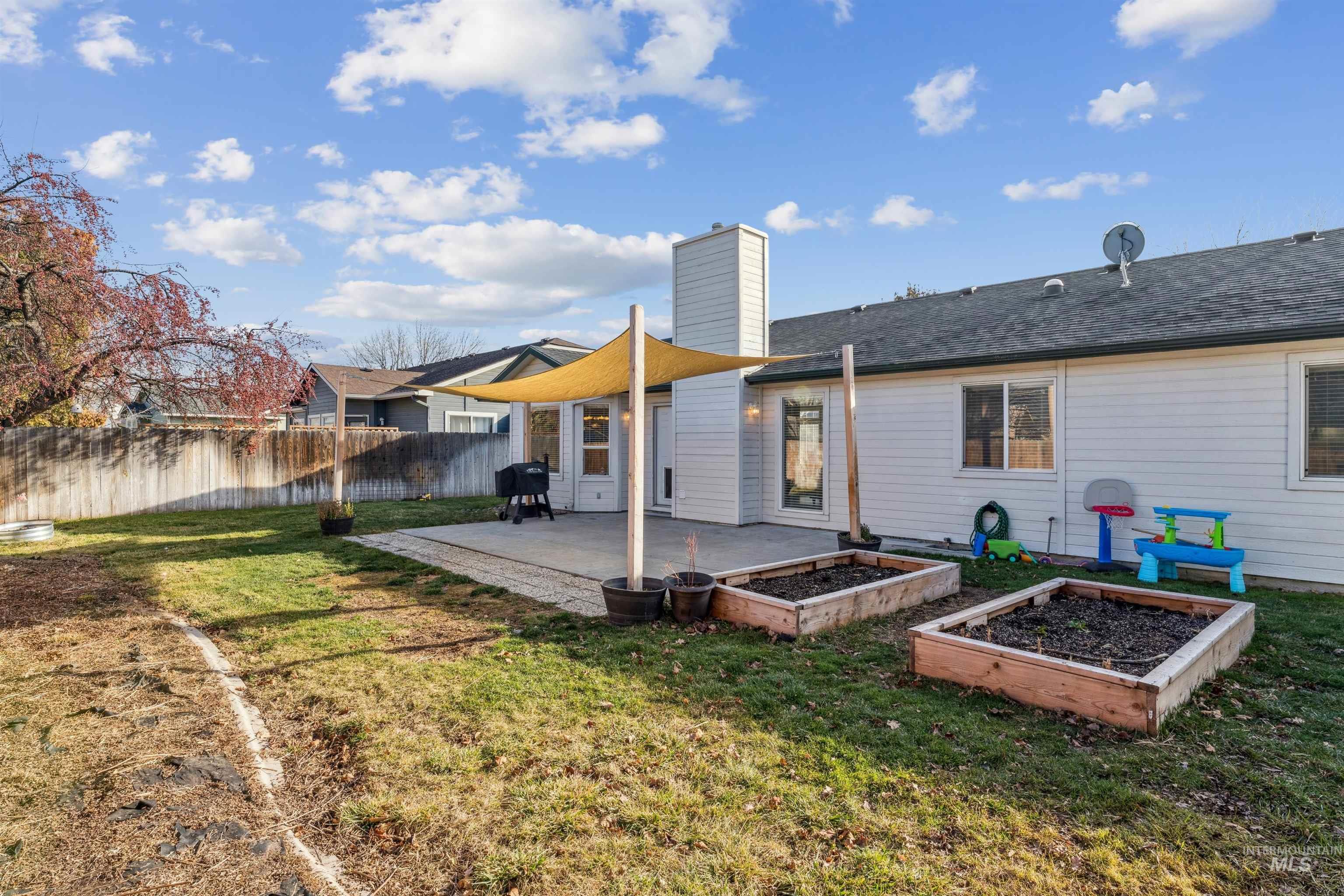 11968 West Bronte Street Boise, ID 83709 - Photo 38 of 48 Rear view of house with a garden, a patio area, and a chimney