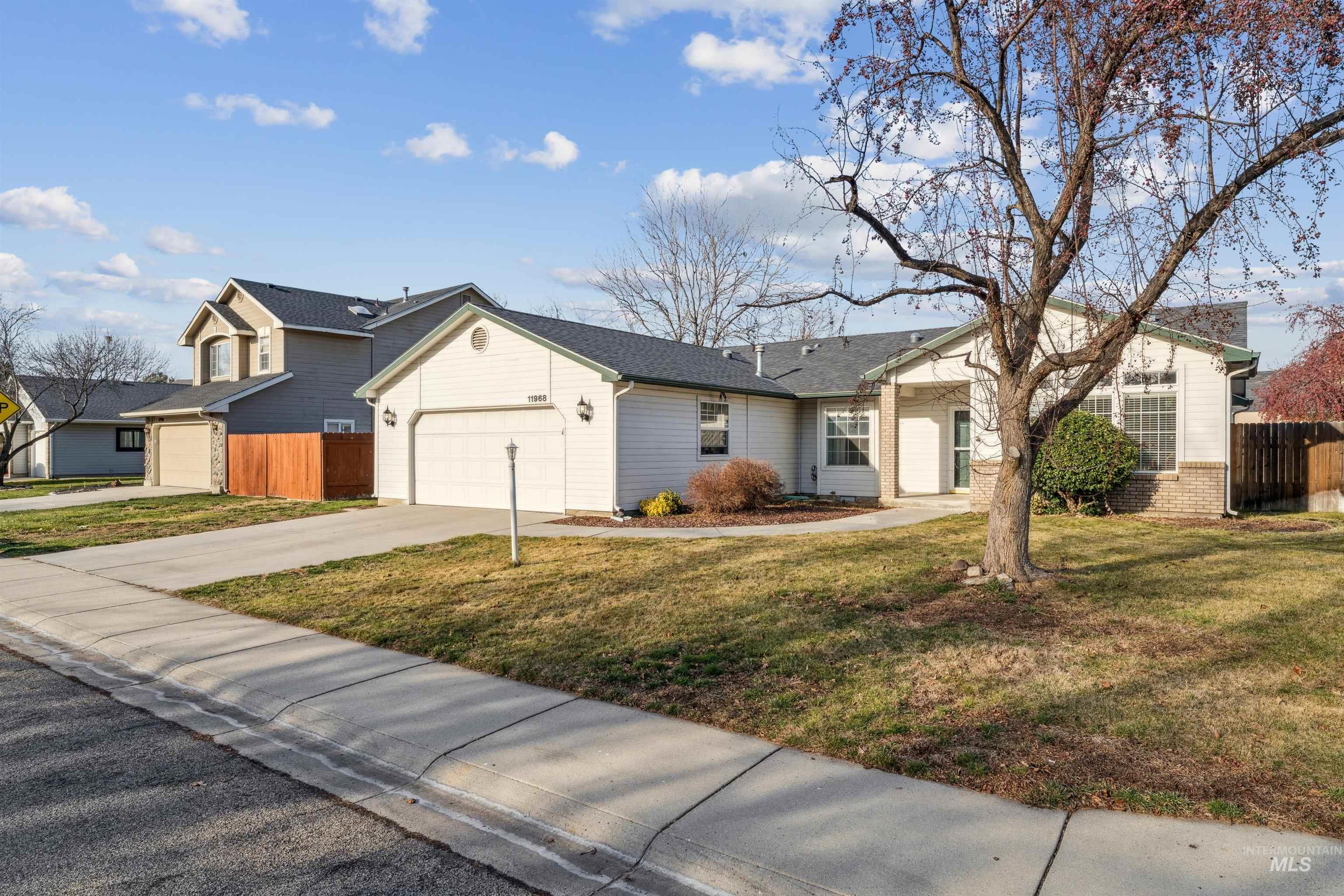 11968 West Bronte Street Boise, ID 83709 - Photo 4 of 48 View of front of house featuring driveway, a garage, and brick siding