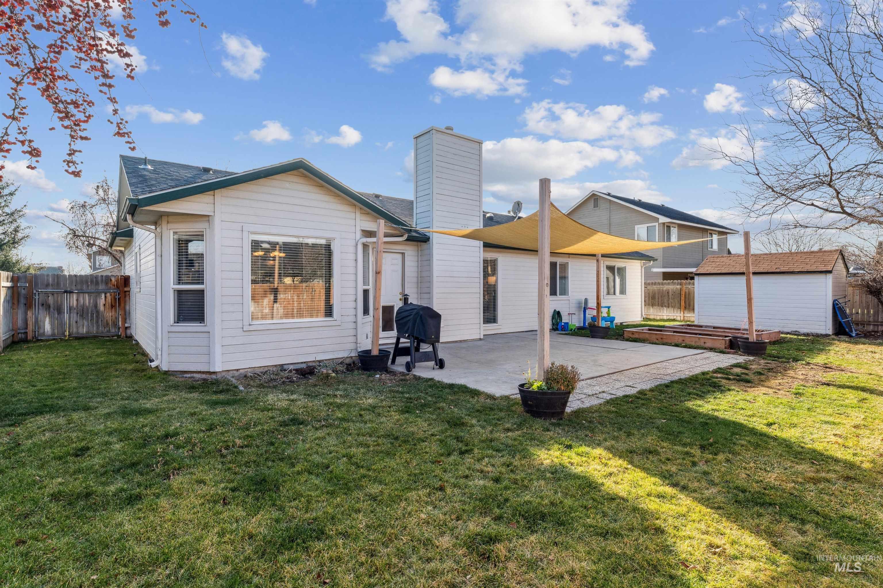 11968 West Bronte Street Boise, ID 83709 - Photo 41 of 48 Rear view of house featuring a fenced backyard, a chimney, a patio, and an outdoor structure