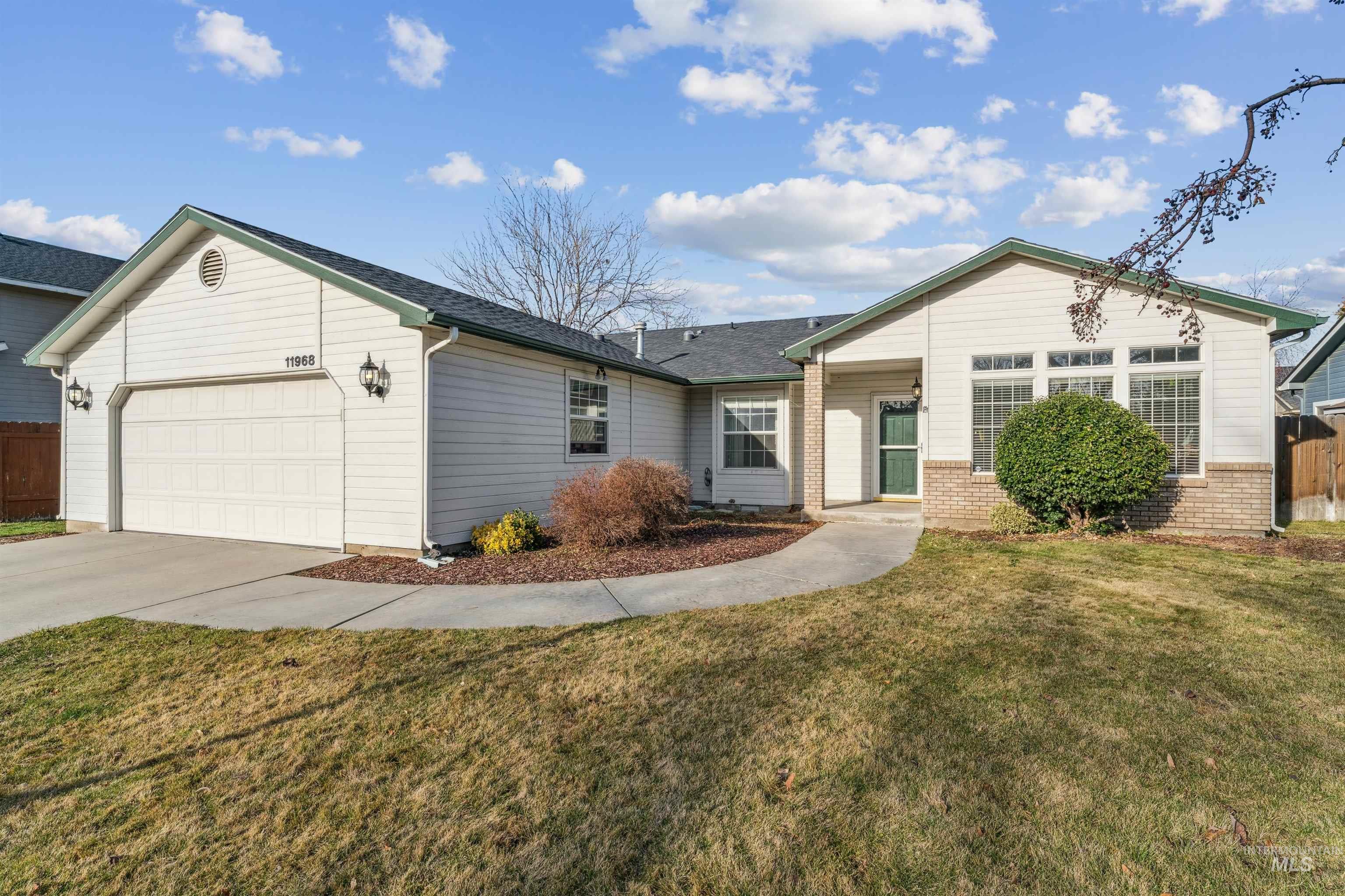 11968 West Bronte Street Boise, ID 83709 - Photo 5 of 48 Ranch-style home featuring a garage, concrete driveway, and brick siding