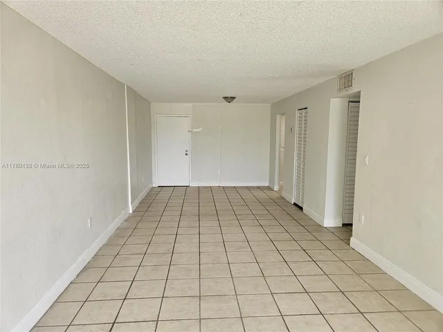 en empty room with white walls and tiles