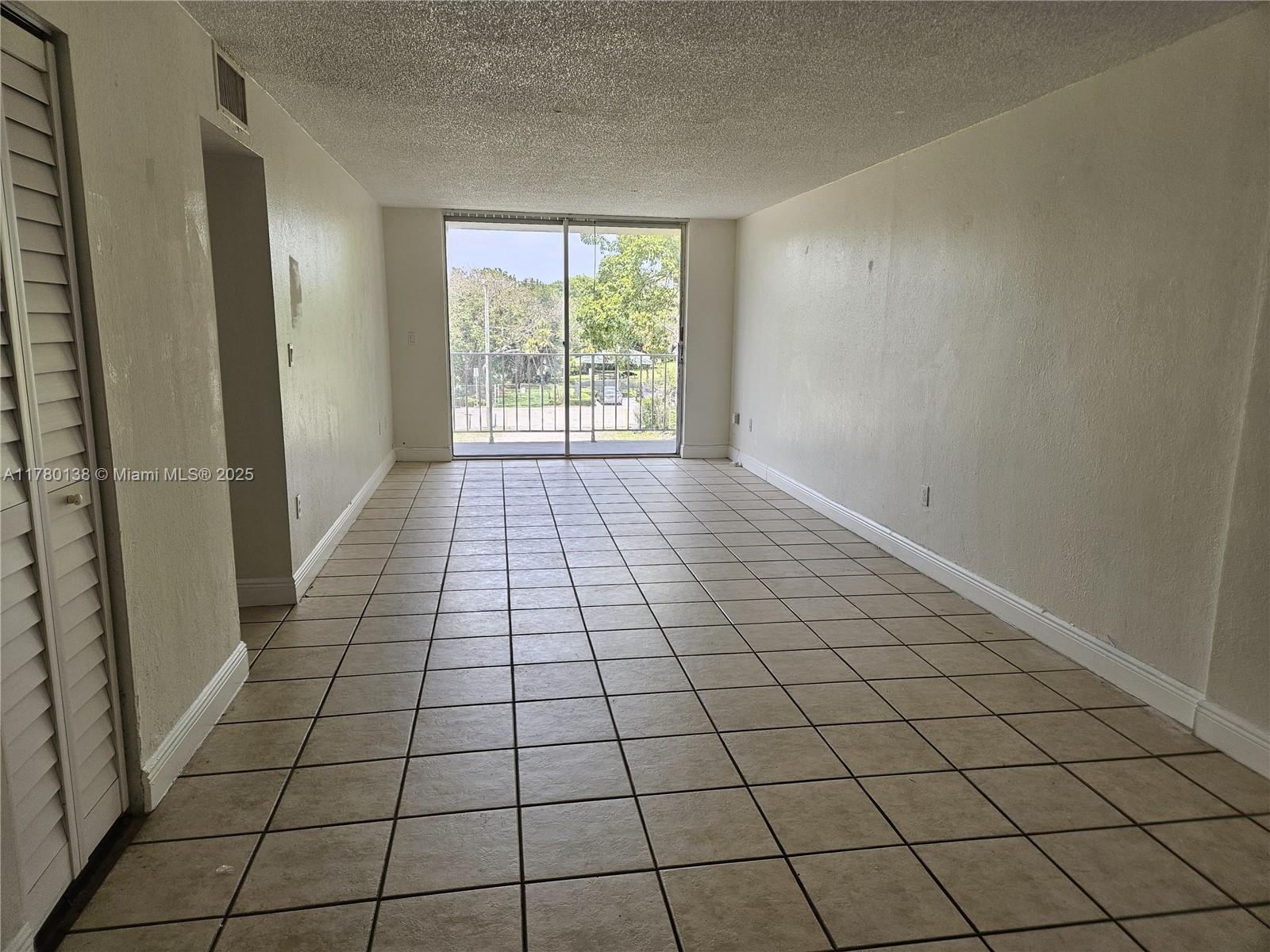 1805 Sans Souci Boulevard, Unit 302R North Miami, FL 33181 - Photo 6 of 33 en empty room with white walls and tiles