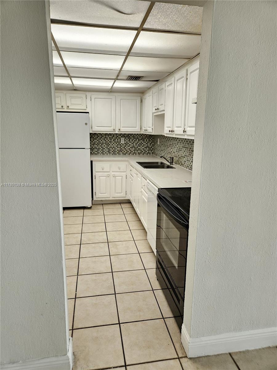1805 Sans Souci Boulevard, Unit 302R North Miami, FL 33181 - Photo 9 of 33 a kitchen with granite countertop a stove a microwave and a refrigerator