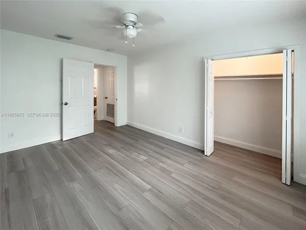 an empty room with wooden floor and closet