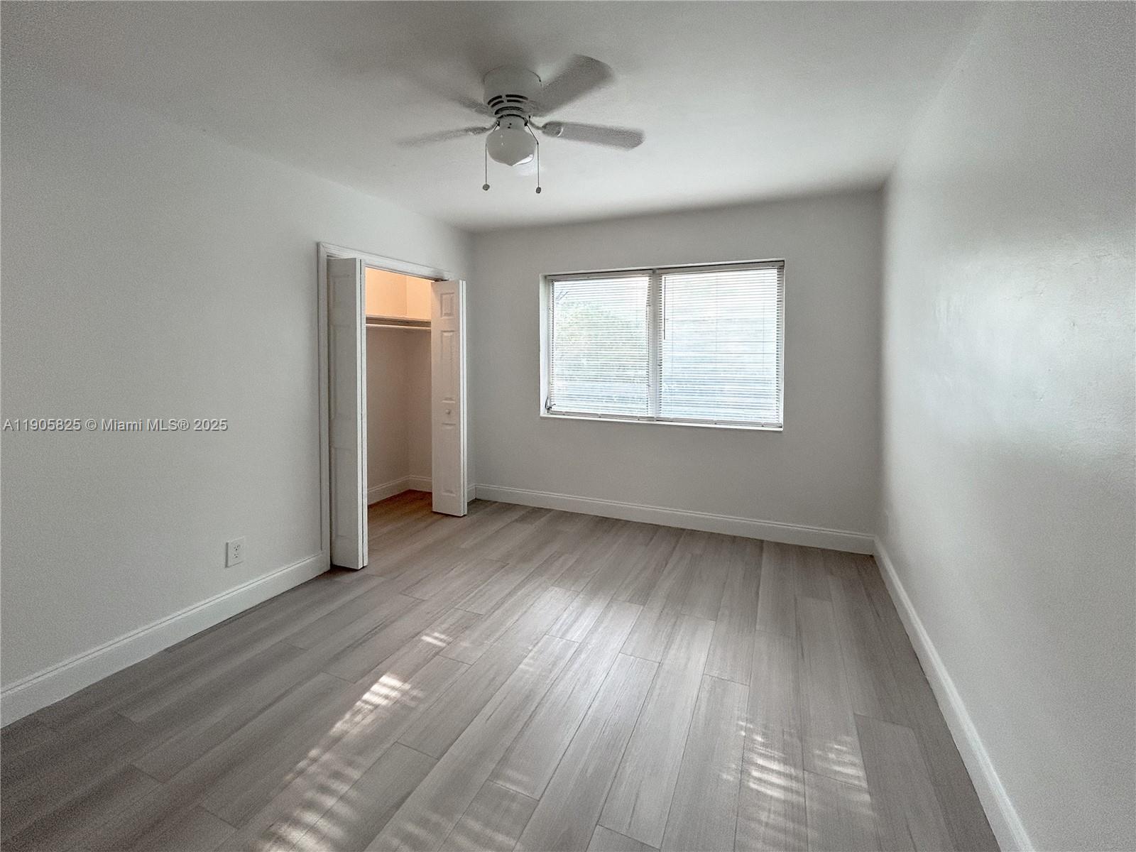 738 Northeast 86th Street, Unit 6 Miami, FL 33138 - Photo 9 of 10 an empty room with wooden floor and windows
