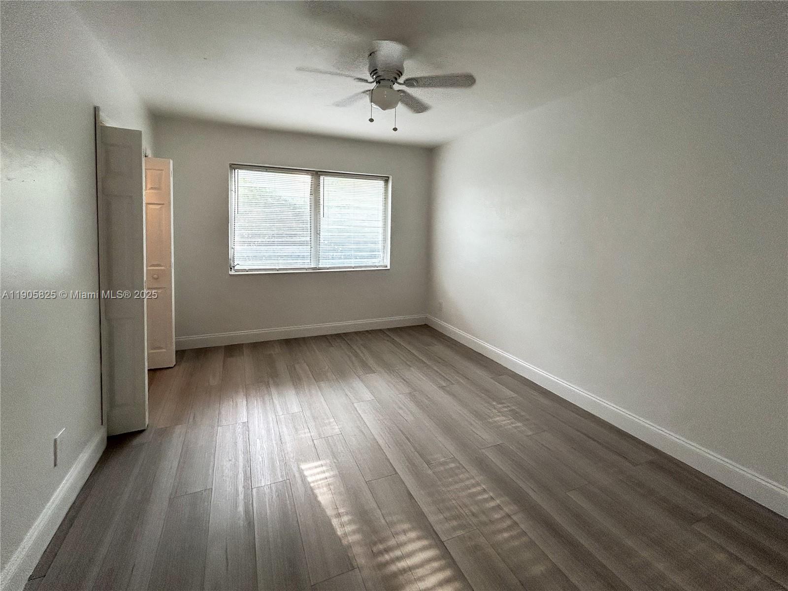 738 Northeast 86th Street, Unit 6 Miami, FL 33138 - Photo 10 of 10 an empty room with wooden floor and windows