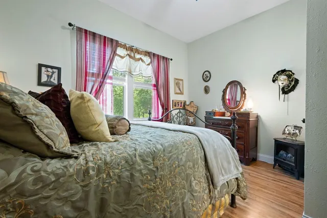 a bedroom with a bed and wooden floor