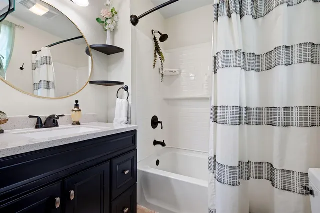 a bathroom with a double vanity sink mirror and bathtub