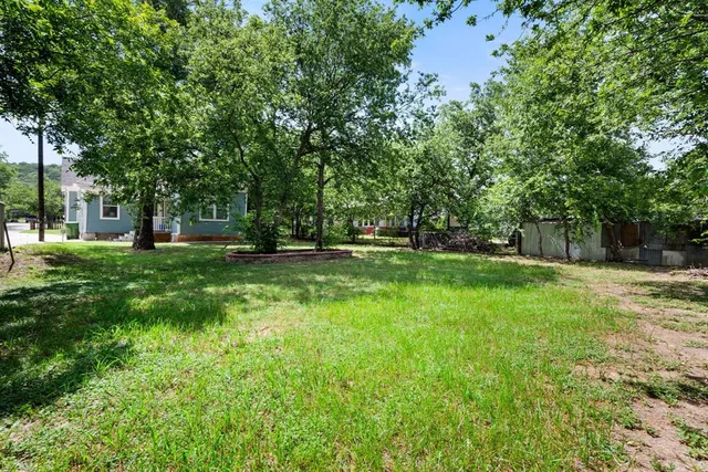 a view of green field with trees in the background