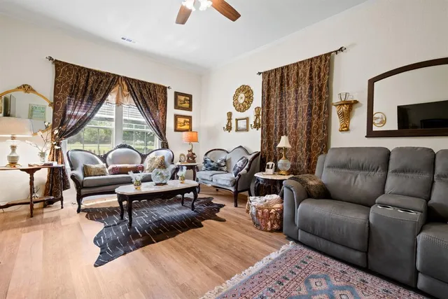 a living room with furniture fireplace and a large window