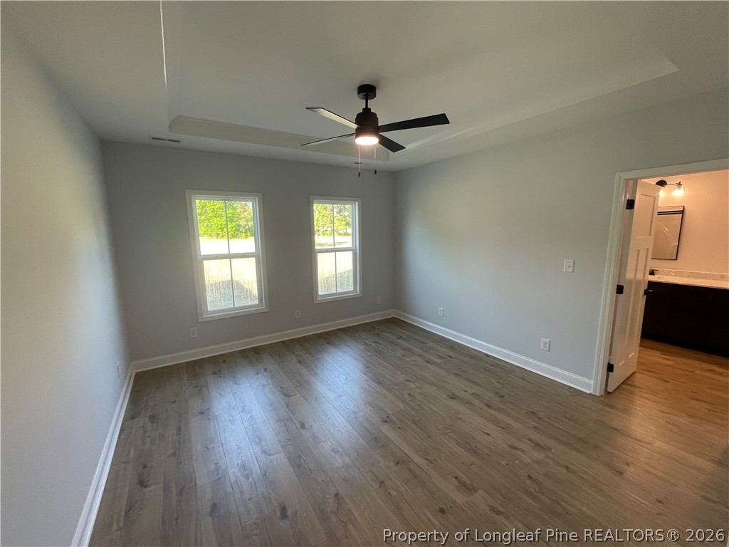 2677 Smith Mill Road Lumberton, NC 28358 - Photo 14 of 27 an empty room with wooden floor ceiling fan and windows