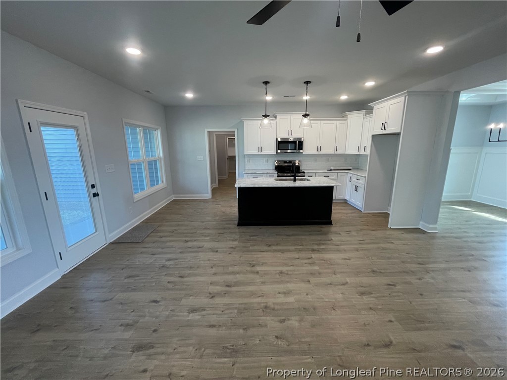 2677 Smith Mill Road Lumberton, NC 28358 - Photo 7 of 27 a large white kitchen with kitchen island a sink a stove and a refrigerator