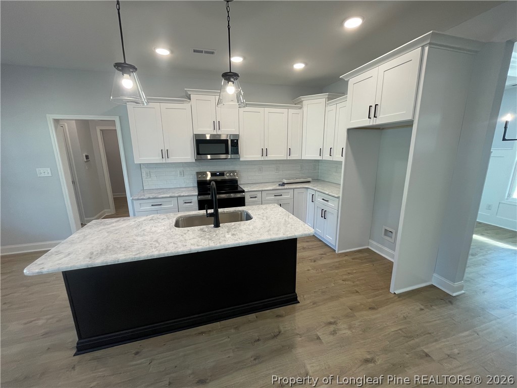 2677 Smith Mill Road Lumberton, NC 28358 - Photo 8 of 27 a kitchen with stainless steel appliances granite countertop a sink a refrigerator a stove a microwave and white cabinets