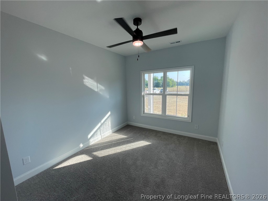 2677 Smith Mill Road Lumberton, NC 28358 - Photo 9 of 27 en empty room with windows and ceiling fan