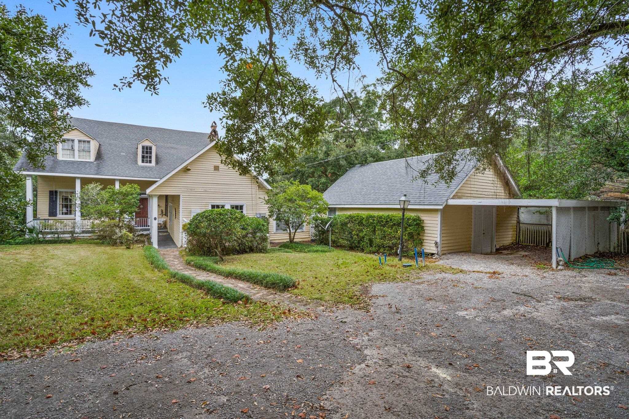 23561 Main Street Fairhope, AL 36532 - Photo 42 of 45 View of front facade featuring covered porch, roof with shingles, driveway, and a carport