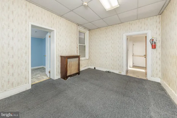 a view of an empty room with closet and a window