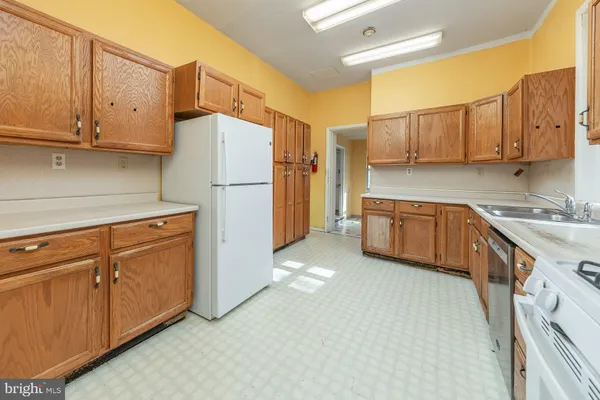 a kitchen with cabinets a sink and white appliances
