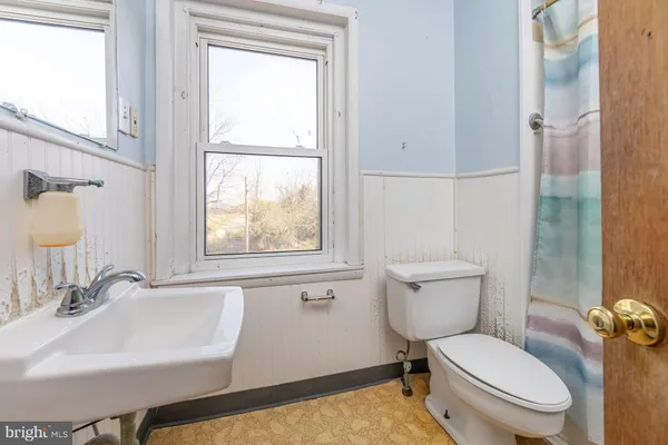 a bathroom with a toilet a sink and a window