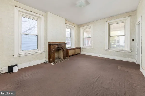 an empty room with windows and cabinet