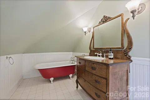 a bathroom with a tub sink and mirror