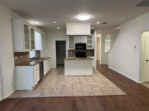 a large kitchen with a large counter top stainless steel appliances and cabinets