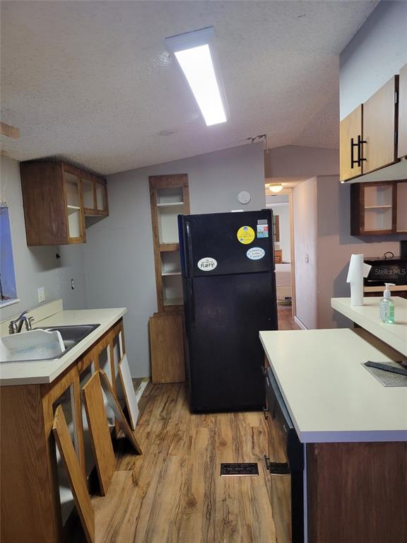 16842 Diagonal Road Hudson, FL 34667 - Photo 3 of 17 a kitchen with a wooden floor a refrigerator and a stove top oven