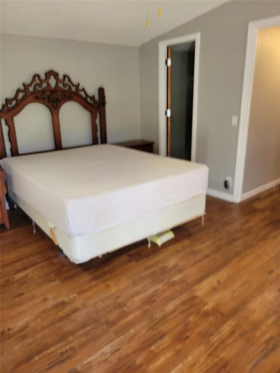 16842 Diagonal Road Hudson, FL 34667 - Photo 8 of 17 a spacious bedroom with a bed and a wooden floor