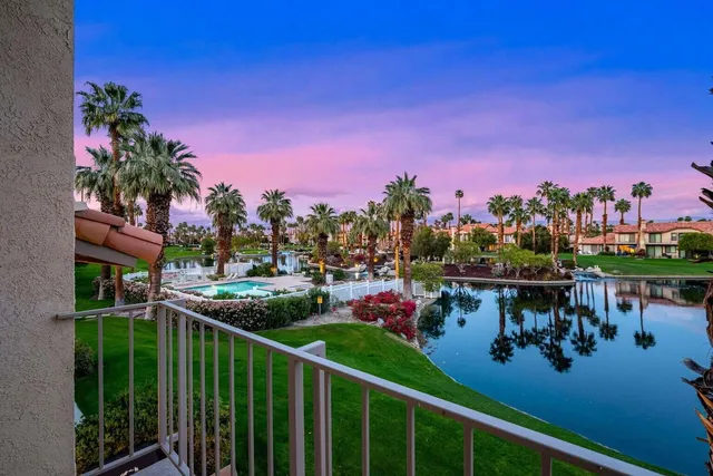 a view of a chairs and table in patio next to a yard