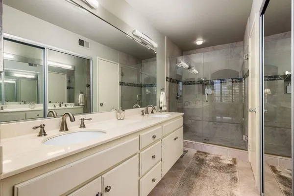 a bathroom with a shower sink and mirror