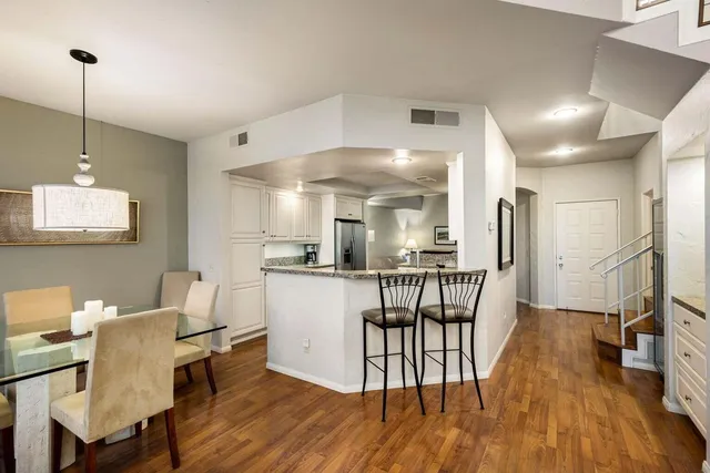 a kitchen with stainless steel appliances kitchen island hardwood floor and a sink