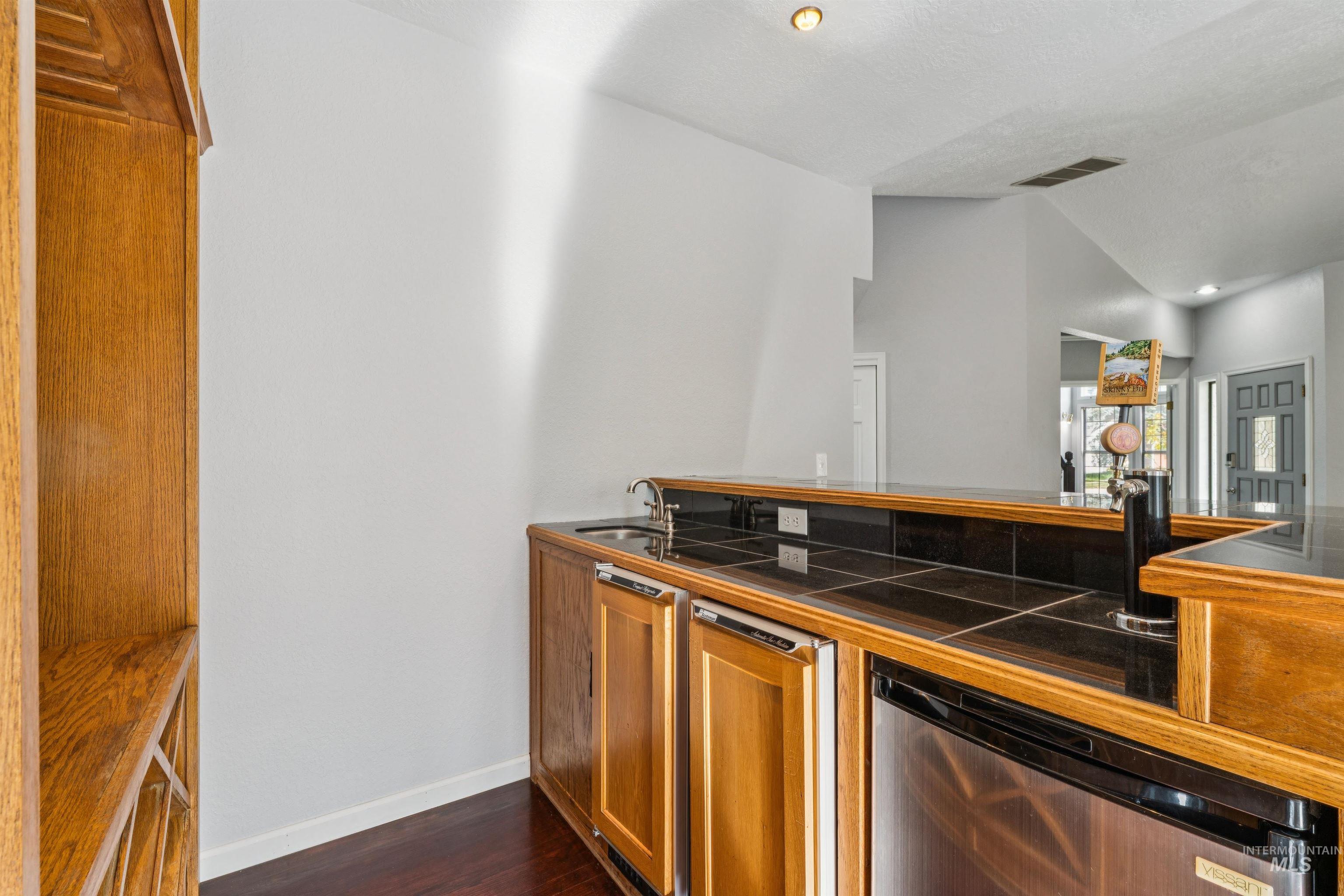 9831 West Ripley Street Boise, ID 83704 - Photo 8 of 47 Custom-built wood bar featuring a tile countertop, integrated shelving, and a wine rack