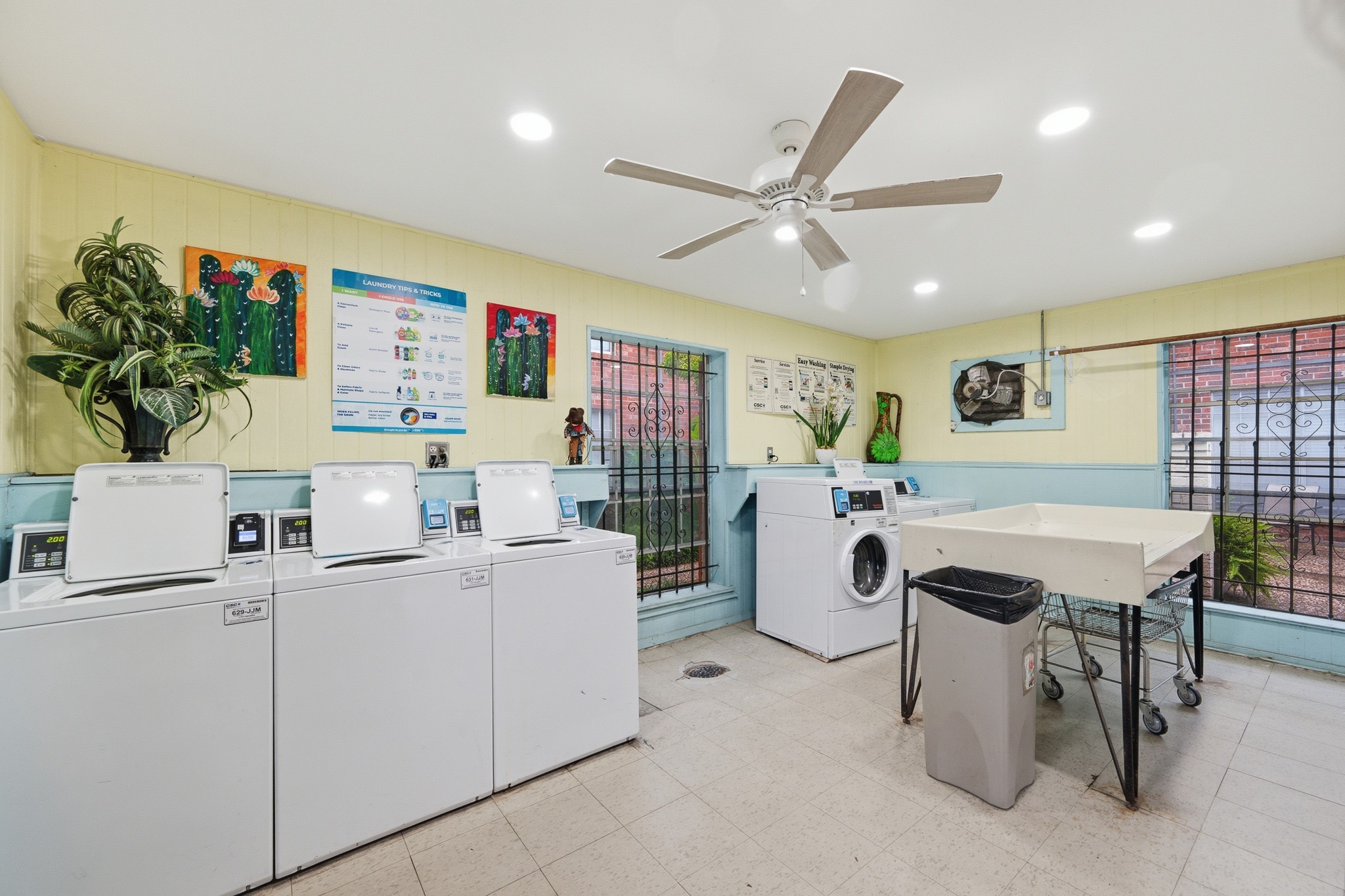 11550 Chimney Rock Road, Unit 133 Houston, TX 77035 - Photo 31 of 40 Spacious laundry room equipped with multiple washers, ample folding space, and vibrant decor, perfect for efficient and enjoyable laundry days.