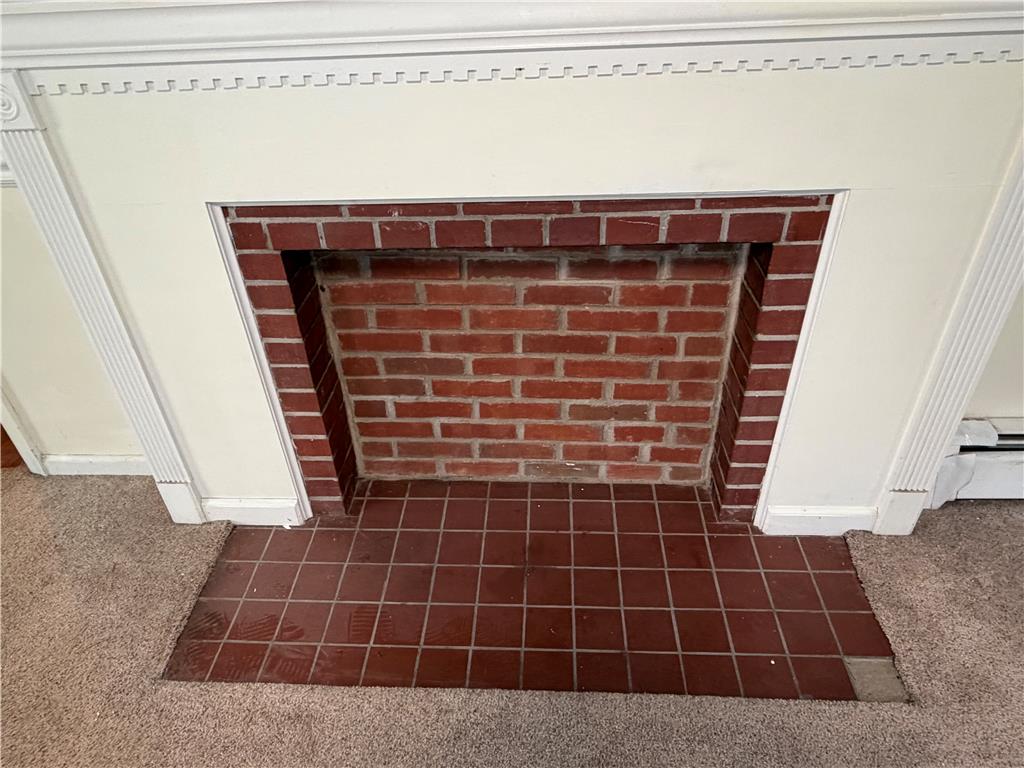 2552 Spring Street Coplay, PA 18037 - Photo 23 of 33 A classic red brick fireplace, framed by ornate white millwork, anchors this cozy space.