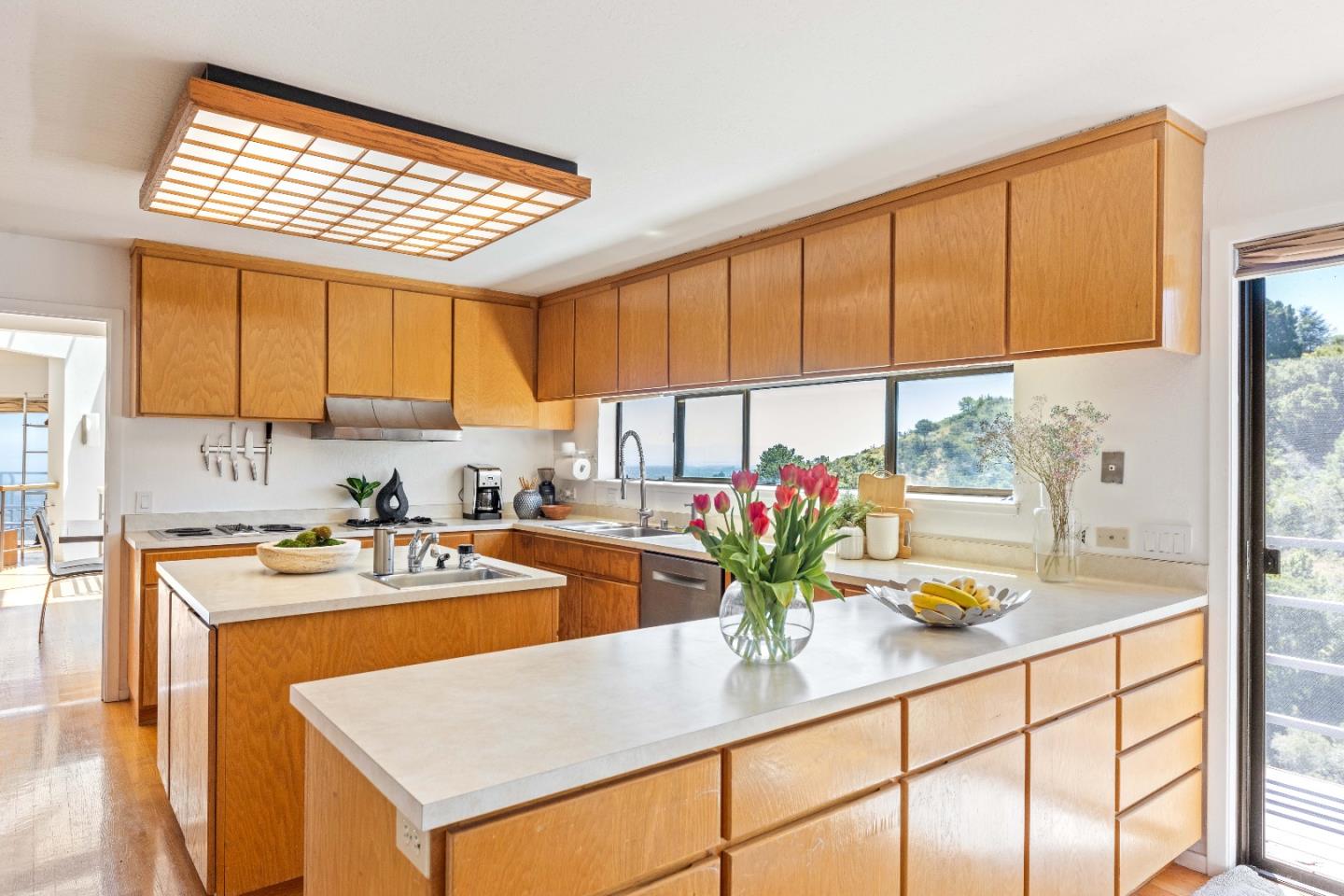 1305 Southdown Road Hillsborough, CA 94010 - Photo 22 of 72 a kitchen with a stove a sink cabinetry and a kitchen island
