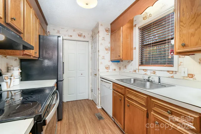 a kitchen with granite countertop stainless steel appliances a sink stove and cabinets