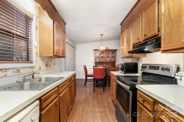 a kitchen with stainless steel appliances a sink a stove and a wooden floors