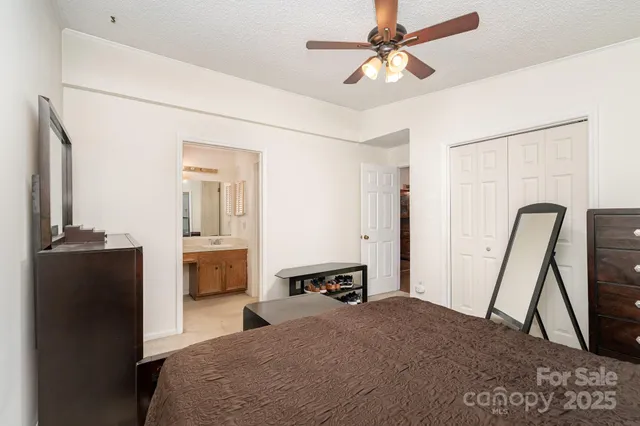 a bedroom with a bed and a mirror on the dresser