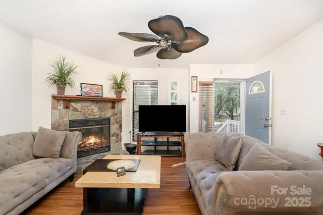 a living room with furniture a fireplace and a flat screen tv
