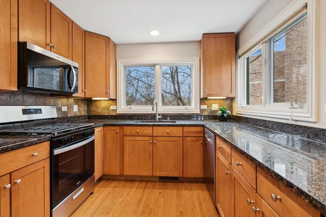 a kitchen with stainless steel appliances granite countertop a refrigerator and a stove top oven