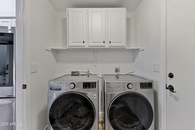 a view of washer and dryer with kitchen in the background