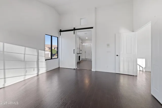 a view of empty room with wooden floor and windows