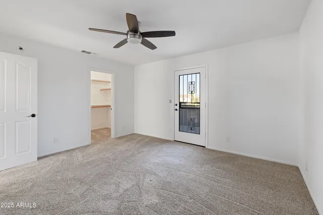 an empty room with closet and windows