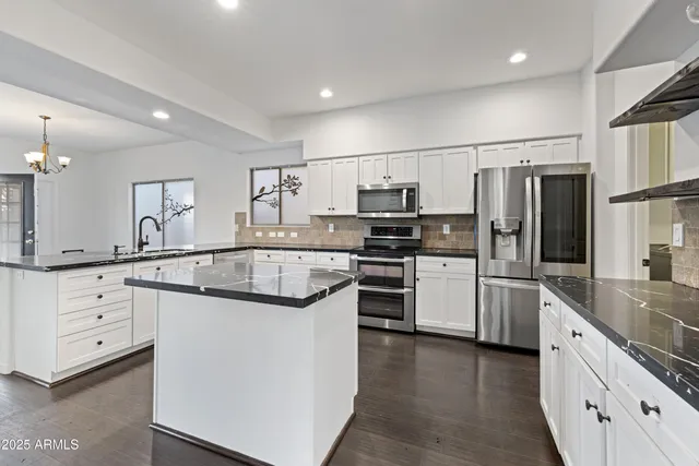 a kitchen with white cabinets appliances and sink