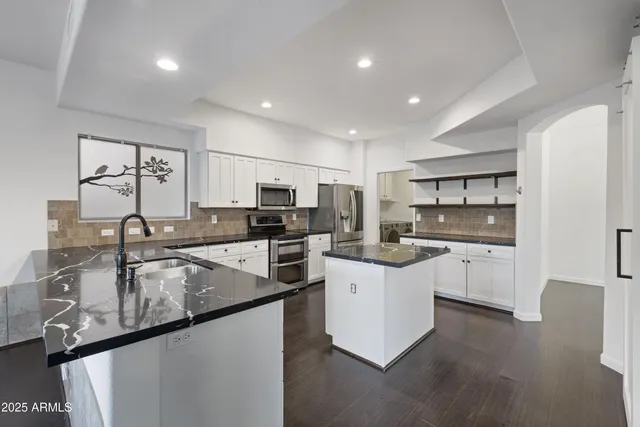 a kitchen with stainless steel appliances a sink stove and refrigerator